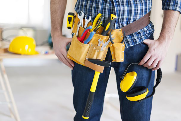 Technician wearing a tool belt with hard hat and ear protection